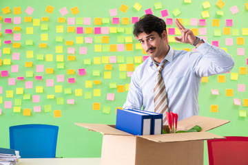 Man collecting his stuff after redundancy in the office with man