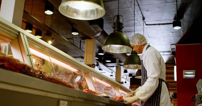 Butcher arranging wrapped meat in refrigerator 4k