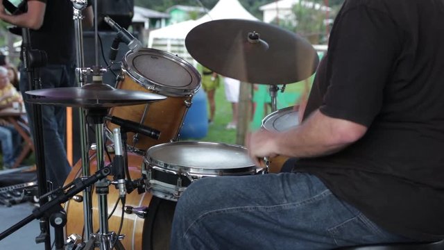 Close up of a drum player doing his performance on stage on a beautiful day during the summer, on a music festival