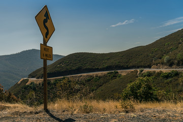 Curvy road sign on a beautiful road way