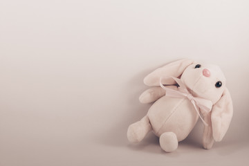card with a lying toy plush rabbit on a white background