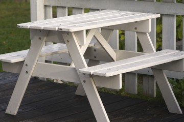 Picnic table in front of white wooden fence