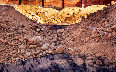 multicolored piles of soil at the construction site. Traces of tractor wheels