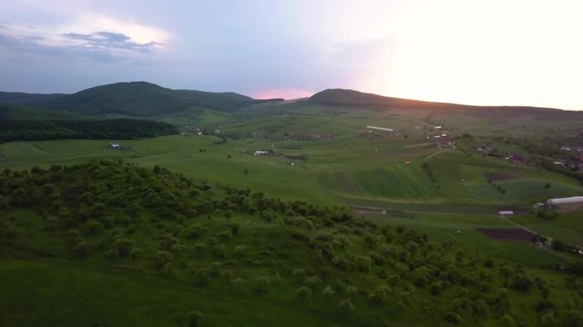 Aerial shot panning out of a beautiful pink hue afternoon sunset in the countryside of Sigmir Romania