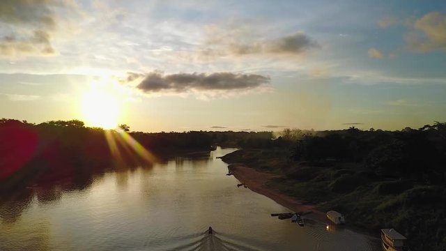 Moving drone view of a sunset with clouds at a Brazillian village Nova Morada and a beautiful river