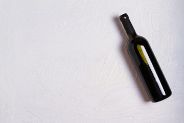 Bottle of wine on white stone texture background. View from above, top studio shot