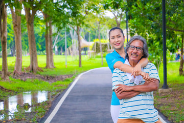 Portrait of happy. Happy Asian senior couple . They are big hug after Jogging in park. They are smiling and happy in good time , husband and wife, love , Photo concept Health and relax time.