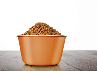 metal bowl full of dog food on a wooden floor isolated on a white background studio shot