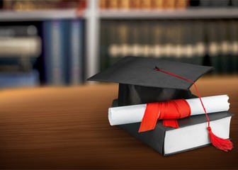 Graduation hat with tassel, diploma with red