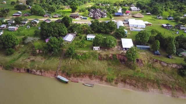 Drone dolly shot to reveal a Brazillian village Nova Morada in the state of Acre, beside a river with boats