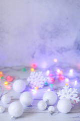 new year or Christmas decorations in silver and white colors with balls, snowflakes and garland bokeh