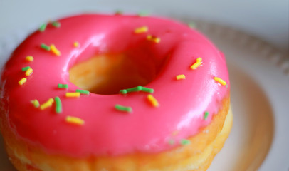 Delicious pink doughnut with white background.