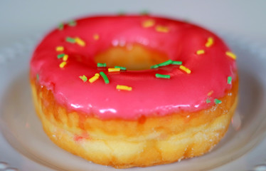 Delicious pink doughnut with white background.