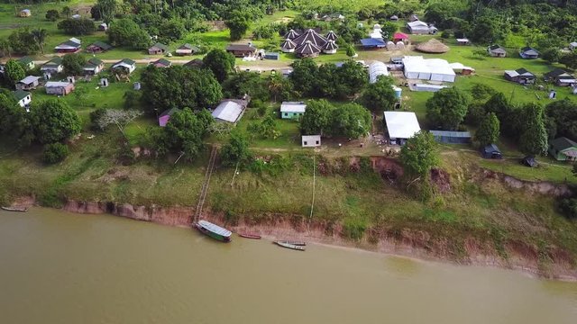 Aerial shot of Brazillian village Nova Morada in the state of Acre, beside a river with boats