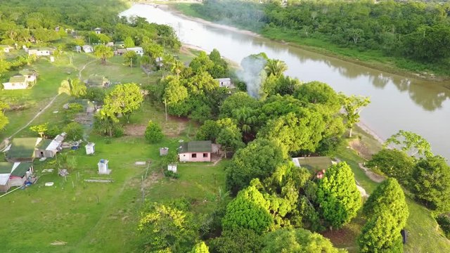 Drone dolly shot to reveal a Brazillian village Nova Morada in the state of Acre, smoke coming out from a house