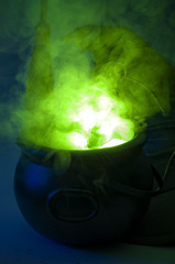 Happy halloween, alchemy and magic spell potion concept with a pot or calderon boiling a green...