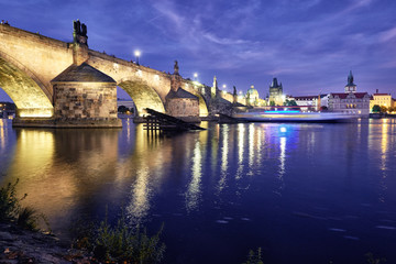  Illuminated Charles Bridge reflected in Vltava river at night in Prague