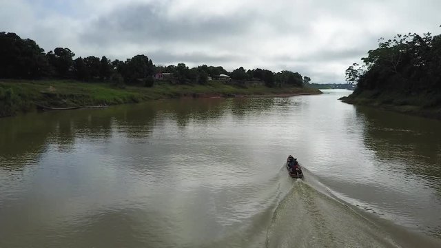 Drone view of a single speed boat sailing on the Envira river in a Brazillian village Nova Morada
