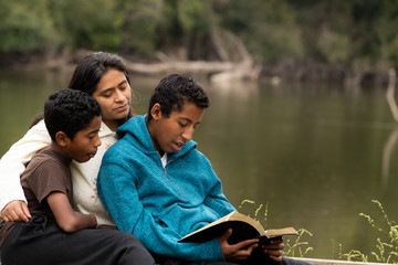 Hispanic Hispanic Woman Praying in Forest Preserve Front of River