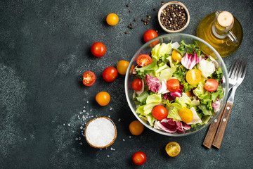 Healthy vegetable salad of fresh tomato, cucumber, onion, spinach, lettuce and pumpkin seeds in bowl. Diet menu. Top view with copy space