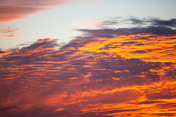 Fototapeta premium view of a bright orange sunset like a fire with burn clouds