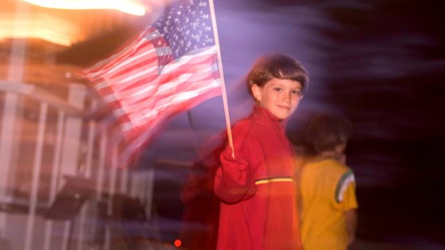 Cinemagraph of a small boy waving an american flag with flag motion.