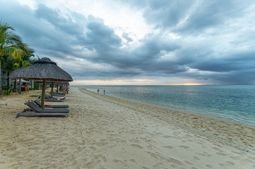 Der Strand von Mauritius mit Meer und Liegen mit Schirm zum Sonnenbaden