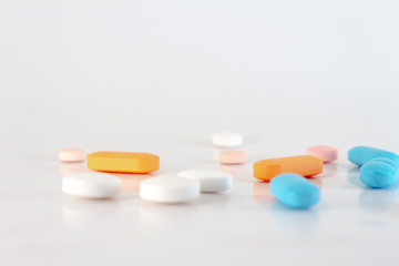 Numerous medications or drugs of different colors in the form of pills and tablets.