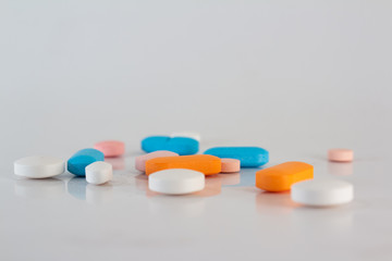 Numerous medications or drugs of different colors in the form of pills and tablets.