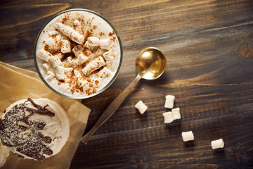 Cup of cappuccino coffee marshmallows on wooden table