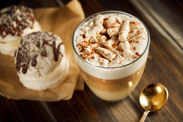 Cup of cappuccino coffee marshmallows on wooden table