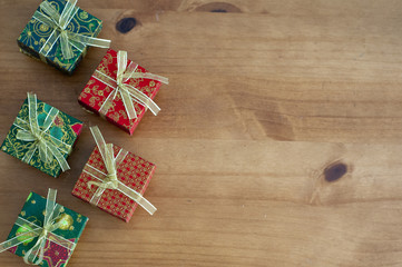 Gifts with a red ribbon on a wooden surface copy space. Gifts in wrapping paper with space for text.