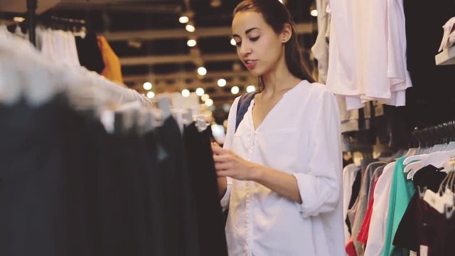 young girl looking and chooses clothes in the store