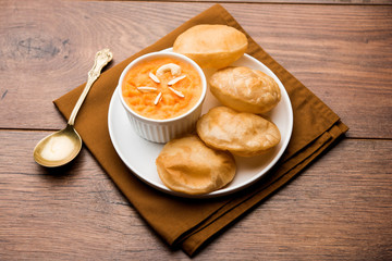 Suji/Sooji Halwa Puri or Shira Poori breakfast, served in a plate and bowl. selective focus