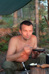 man having dinner at the forest camp