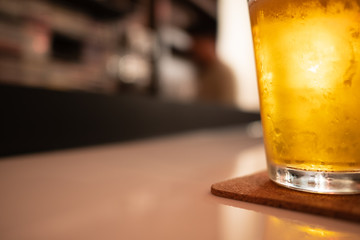 glass of cold craft beer and shadow on white table at bar