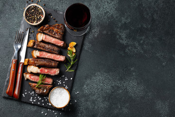 Sliced steak Striploin, grilled with pepper, garlic, salt and thyme served on a slate chopping...