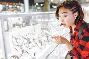 Happy surprised Woman looking for Wristwatches in shop