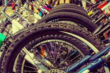 Fototapeta na wymiar Used bicycles stand on a special rack, wheels - close-up