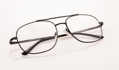 Eyeglasses And Its Reflection Against Light Background