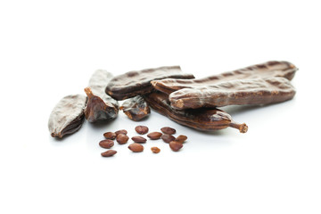 Sweet carob pods with seeds on white background