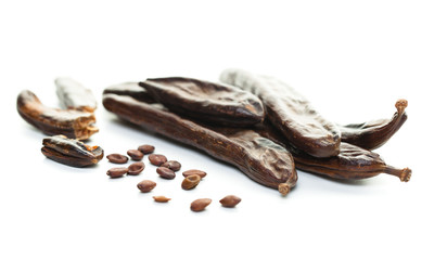 Carob. Healthy organic carob pods with seeds on white background