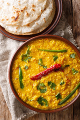 Spicy Indian thick soup Dal Tadka is a popular North Indian recipe close up in a bowl. Vertical top view