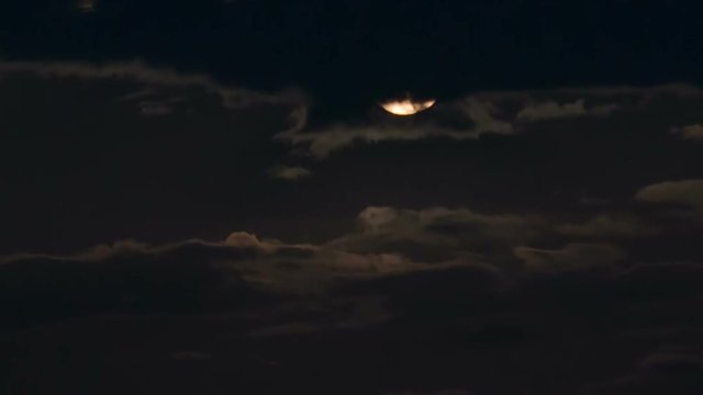 The Moon rising on a cloudy night. Time Lapse
