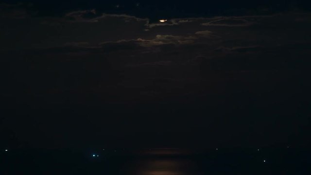 The Moon rising over the sea. Time Lapse of moonrise