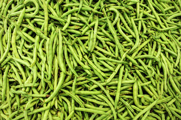 Pile of wet green (string) beans  displayed on food market. Abstract healthy nutrition background.