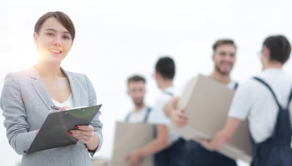 Woman manager holding clipboard on blurred background with mover