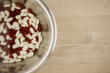 Fototapeta na wymiar legumes - a source of protein and micronutrients: red and white beans in a metal plate on the table, location right; vegetarian diet and a healthy lifestyle.