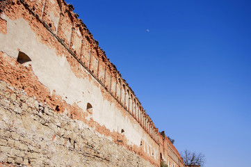 Long wall of the old castle against the background of a blue sky (concept advertisement)