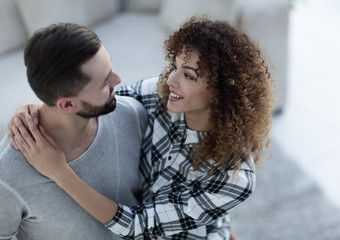 young couple standing in new living room and looking at camera